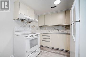 Toronto (Pleasant View) apartment for rent - A white oven and refrigerator in a kitchen with beige cabinets.