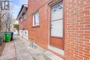 Toronto (Pleasant View) apartment for rent - A red brick house with a white door and a green trash can.