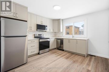 Ottawa duplex for rent - A kitchen with a refrigerator, microwave, oven, and sink.