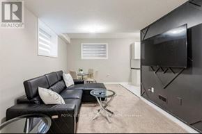Kitchener apartment for rent - A living room with a black leather couch and a flat screen TV mounted on the wall.