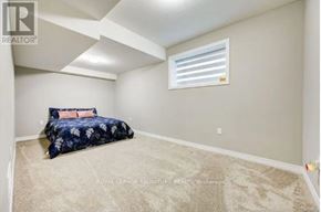 Kitchener apartment for rent - A bedroom with a bed, carpet, and a window.