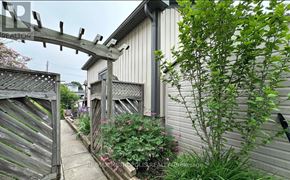 Clarington (Courtice) apartment for rent - A wooden gate leads to a house with a garden.