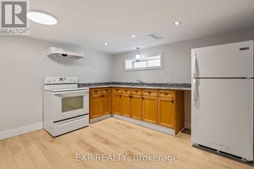 London East (East M) apartment for rent - A kitchen with wooden cabinets and white appliances.