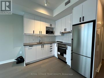 Ottawa condo for rent - A kitchen with white cabinets and a stainless steel refrigerator.