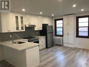 Barrie (Cundles East) apartment for rent - A kitchen with white cabinets and a black refrigerator.