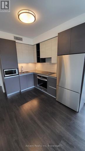 Richmond Hill (Doncrest) condo for rent - A modern kitchen with dark wood floors and stainless steel appliances.