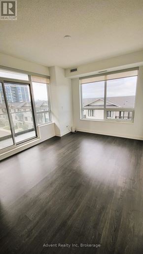 Richmond Hill (Doncrest) condo for rent - A room with wooden floors and large windows overlooking a cityscape.