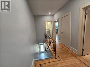 Hamilton apartment for rent - A bedroom with a bed, dresser, and a shelf with a clock and a plant.