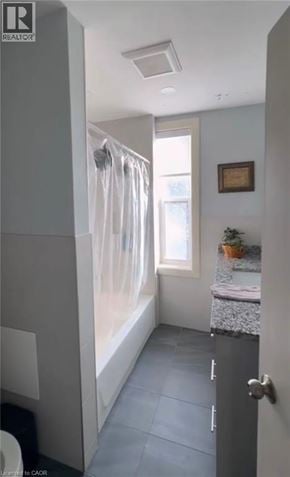 Hamilton apartment for rent - A bathroom with a toilet, sink, and shower.