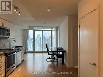 Toronto (Church-Yonge Corridor) condo for rent - A kitchen with a dining table and chairs in front of a window with a view of the city.