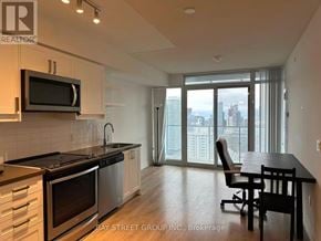 Toronto (Church-Yonge Corridor) condo for rent - A kitchen with a black counter top and stainless steel appliances.