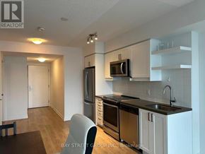 Toronto (Church-Yonge Corridor) condo for rent - A kitchen with a black countertop and white cabinets.