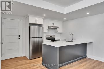Russell apartment for rent - A modern kitchen with a stainless steel refrigerator and a white countertop.