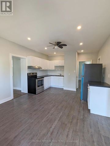 Kawartha Lakes (Lindsay) multi-family for rent - A kitchen with white cabinets and a black fridge.