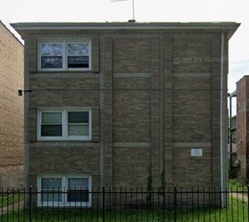 Chicago apartment for rent - A brick building with a black fence in front.