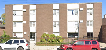 Chicago apartment for rent - A red SUV is parked in front of a brick building.