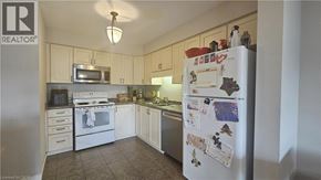 Kitchener townhouse for rent - A kitchen with a refrigerator covered in magnets and papers.