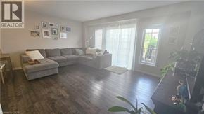 Kitchener townhouse for rent - A living room with a grey couch and a wooden floor.