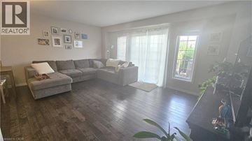 Kitchener townhouse for rent - A living room with a grey couch and a wooden floor.