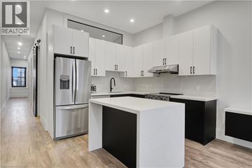 Cambridge apartment for rent - A modern kitchen with white cabinets and a central island.
