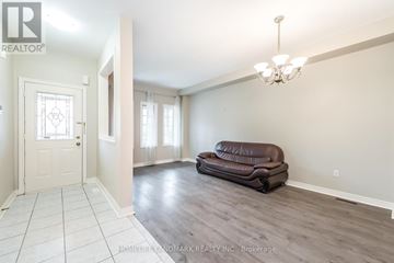 Markham (Village Green-South Unionville) apartment for rent - A living room with a brown leather couch and a chandelier.