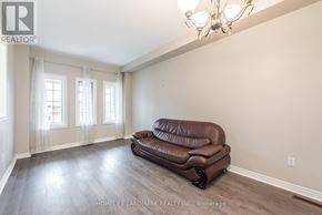 Markham (Village Green-South Unionville) apartment for rent - A brown leather sofa sits in a room with wooden floors and a chandelier.