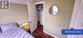 Toronto (Brookhaven-Amesbury) apartment for rent - Bedroom one has a bed and a mirror on the wall.