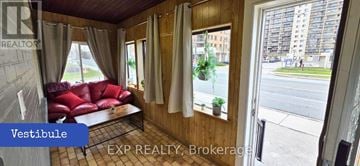 Toronto (Brookhaven-Amesbury) apartment for rent - A living room with a red couch and a window overlooking a street.