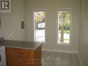 Toronto (Alderwood) multi-family for rent - A kitchen with a counter top and a window with a view of a street.