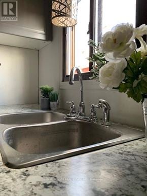 Clarington mobile home for rent - A modern kitchen with a stainless steel sink and a vase of white flowers.