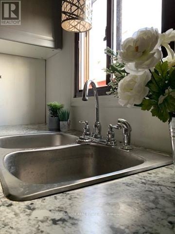 Clarington mobile home for rent - A modern kitchen with a stainless steel sink and a vase of white flowers.