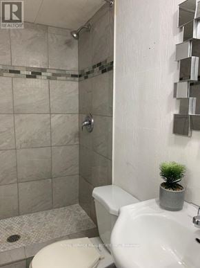 Clarington mobile home for rent - A white toilet sits next to a sink in a bathroom.