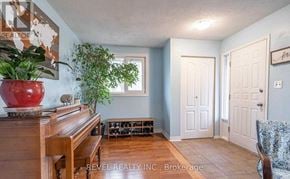 Haldimand apartment for rent - A living room with a piano, two doors, and a plant.
