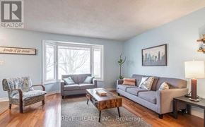 Haldimand apartment for rent - A living room with a grey couch, a wooden coffee table, and a chair with a floral pattern.