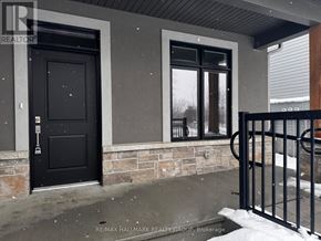 Brockville townhouse for rent - A black door and window on a house with a black gate.