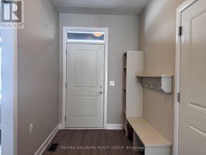 Brockville townhouse for rent - A white door is in a hallway with a bench to the side.