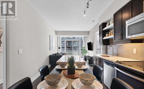 Toronto (Waterfront Communities) condo for rent - A modern kitchen with a dining table set for four.