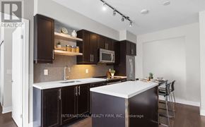 Toronto (Waterfront Communities) condo for rent - A modern kitchen with dark brown cabinets and white countertops.