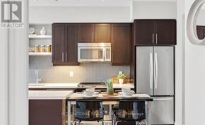 Toronto (Waterfront Communities) condo for rent - A modern kitchen with dark brown cabinets and stainless steel appliances.