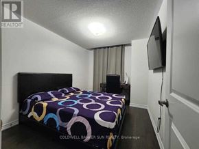 Whitby (Lynde Creek) apartment for rent - A bedroom with a bed, a television, and a window with curtains.