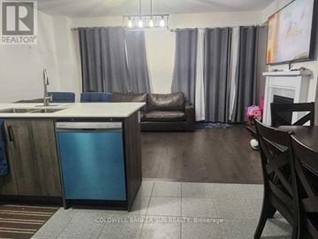 Whitby (Lynde Creek) apartment for rent - A kitchen with a sink, a fridge, a chair and a table.