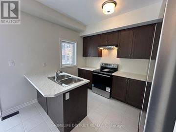 Brantford townhouse for rent - A kitchen with a sink and a refrigerator.