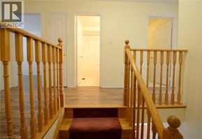 Mississauga townhouse for rent - A wooden staircase with a red carpeted step.