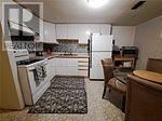Toronto (Pleasant View) apartment for rent - A kitchen with a white fridge and a black and white rug.