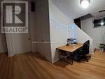 Toronto (Pleasant View) apartment for rent - A room with a desk and a Realtor sign on the wall.
