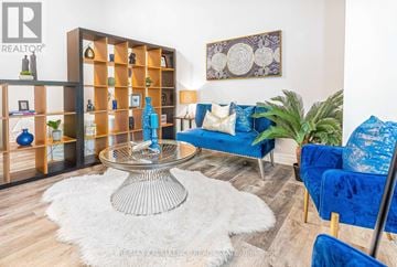 Mississauga (Hurontario) condo for rent - A living room with a glass table and blue couches.