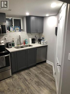 Hamilton apartment for rent - A kitchen with a sink, stove, and cabinets.