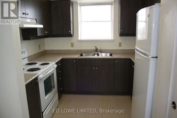Barrie (East Bayfield) townhouse for rent - A kitchen with a stove, sink, and refrigerator.