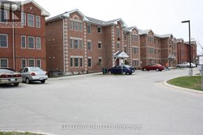 Barrie (East Bayfield) townhouse for rent - A parking lot with cars and apartment buildings in the background.