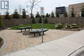 Barrie (East Bayfield) townhouse for rent - A sign with a blue background and a white symbol is on a pole in a park.